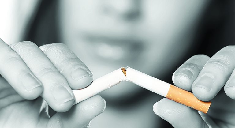 Woman breaking cigarette in half