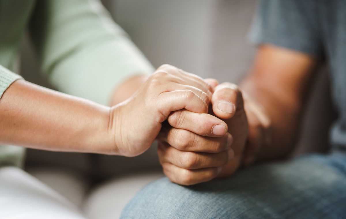 People holding hands in comfort